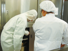 写真:調理場の収納棚の整理状況を確認している職場巡視の様子