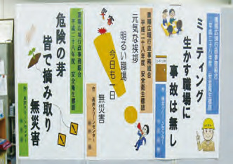 写真：安全衛生標語優秀賞３点がイラスト入りポスターとして掲示されている