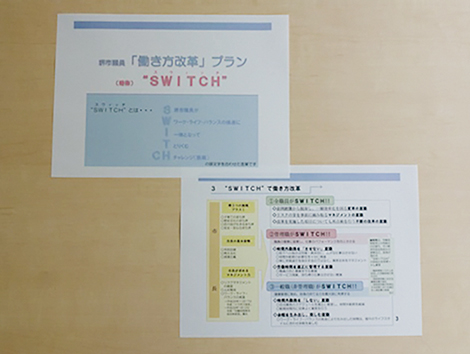 写真：改革プランSWITCHの説明を書いた用紙が2枚並んでいる。